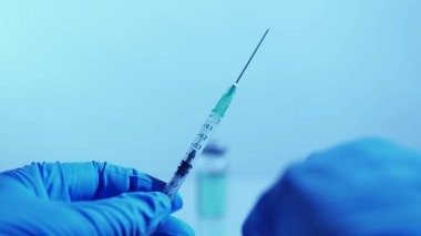 Doktor ya da hemşire şırınga ve aşıyla ilaç aşısı yapıyor. Sağlık hizmetleri. Elleri şırıngayla dolu aşı. Hazırlık. Tıbbi aşı araştırması ve bağışıklık bilimi.