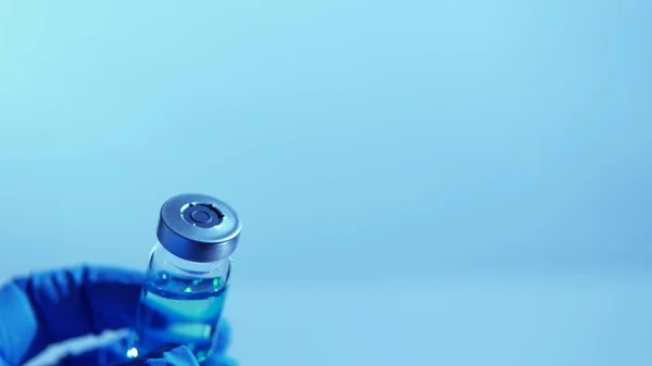 Medical vaccine scientist holding the glass vial with vaccine. Concept of developing research of vaccine against Coronavirus, COVID-19. Pre-clinical evaluation, clinical phase trials development test.