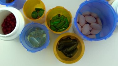 Yukarıdan farklı haplar ve şişeler. Eczane masasının rotasyonu. Modern ilaç ve eczane endüstrisi konsepti. Coronavirus COVID 'yi önlemek veya tedavi etmek için araştırma ve geliştirme ilaçları.