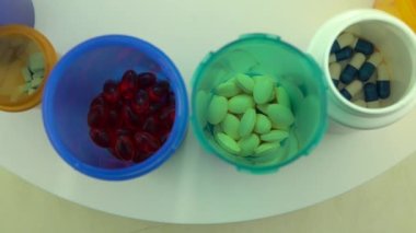 Yukarıdan farklı haplar ve şişeler. Eczane masasının rotasyonu. Modern ilaç ve eczane endüstrisi konsepti. Coronavirus COVID 'yi önlemek veya tedavi etmek için araştırma ve geliştirme ilaçları.