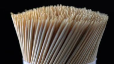 Makro, ahşap bambu kürdanları yan taraftan yavaş çekimde dönüyor. Yemekten sonra diş hijyeni ya da diş bakımı kavramı. Kariyer önleme. Diş Sağlığı Hizmetleri.