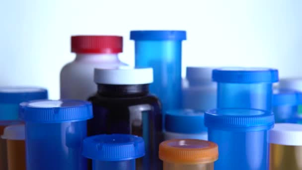Eri pillereitä pullot makro lähikuva ammuttu. Liukuu apteekkipöydän lähellä. Nykyaikainen lääke- ja apteekkiteollisuuden käsite. Tutkimus ja kehitys lääkkeitä estää tai hoitaa coronavirus COVID idea. — kuvapankkivideo