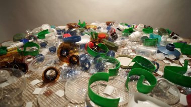 Evdeki plastik çöp yığını masada toplandı. Tek kullanımlık ya da tek kullanımlık atık kullanımı. Plastikten yapılmış şehir çöplüğü. Boş şişe ve bardaklar çevresel kirlilik yaratır.
