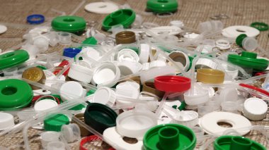 Tek kullanımlık plastik çöp. Geri dönüşümsüz plastik atıkla çöp sahalarının aşırı kirlenmesine dikkat çekmek. Masanın üzerinde biyolojik olarak çözünemeyen zehirli bir çöp var. Çevre sorunları.