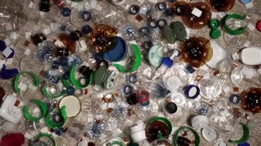 Evdeki plastik çöpler masanın üzerinde. Atıklar atıldı, denizciden toplandı. Plastikten yapılmış şehir çöplüğü. Boş şişe ve bardaklar çevresel kirlilik ve ekolojik sorun yaratıyor.