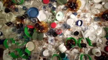 Tek kullanımlık plastik çöp. Geri dönüşümsüz plastik atıkla çöp sahalarının aşırı kirlenmesine dikkat çekmek. Masanın üzerinde biyolojik olarak çözünemeyen zehirli bir çöp var. Çevre sorunları.