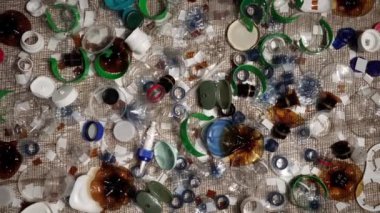 Evdeki plastik çöpler masanın üzerinde. Atıklar atıldı, denizciden toplandı. Plastikten yapılmış şehir çöplüğü. Boş şişe ve bardaklar çevresel kirlilik ve ekolojik sorun yaratıyor.
