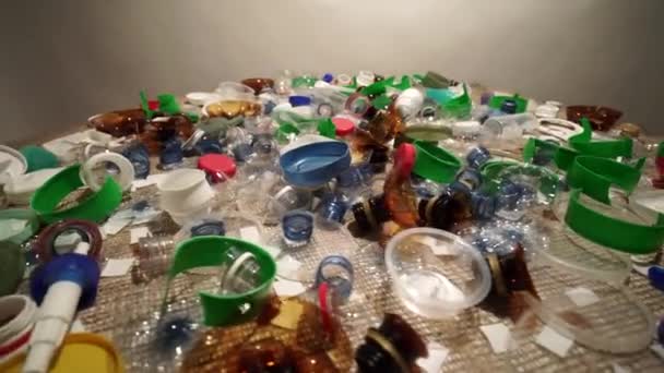 Jednorázový plastový odpad z jedné domácnosti. Přinést povědomí o nadměrném znečištění skládek nerecyklovatelným plastovým odpadem. Toxický biologicky nerozložitelný odpad na stole. Environmentální otázky. — Stock video