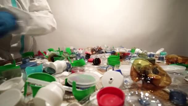 Recyklujte dělníka s modrými rukavicemi, tříděním jednou použitých plastových lahví a odpadků. Zobrazení zařízení na recyklaci. Plastové odpadky přetékají a poškozují životní prostředí, ohrožují volně žijící živočichy. — Stock video