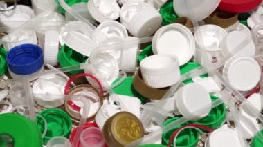 Plastik şişe parçaları, bardaklar, mantarlar, pipetler, su ve şampuan şişeleri, krem ambalajlar ve masaya atılan diğer bir kerelik çöpler. Çevre kirliliği, geri dönüşüm, atık yönetimi sorunu.