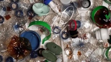 Evdeki plastik çöpler masanın üzerinde. Atıklar atıldı, denizciden toplandı. Plastikten yapılmış şehir çöplüğü. Boş şişe ve bardaklar çevresel kirlilik ve ekolojik sorun yaratıyor.