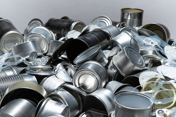 Metal tins, cans and jar garbage from household on the table. City home trash made of aluminum. Empty used, food and drink steel packaging waste and scrap discarded sorted and ready to recycle.