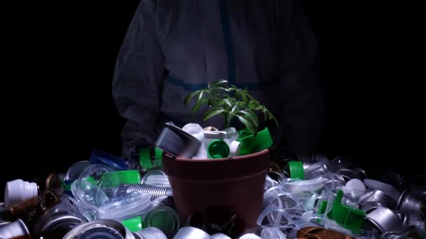 汚染された汚染された有毒ゾーンからの汚染されたプラスチックごみで成長している植物を示す生態学者。黙示録、生態学的災害と緑の環境の死の概念. — ストック動画
