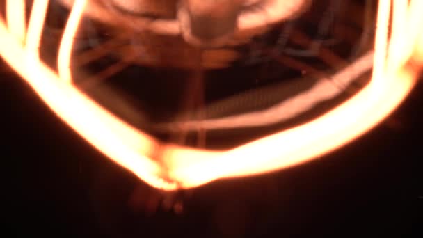 Powolny ruch kamery w makro ujawnić ostre szczegóły w części żarówki wolframowej lub żarówki Edisona. Przytulny widok na czarne tło, makro zbliżenie strzał starego światła retro vintage. 4k. — Wideo stockowe