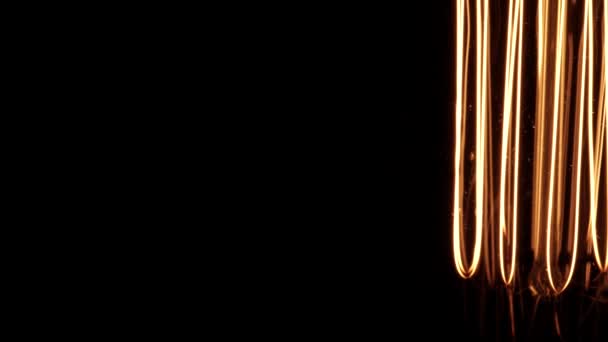 Tungsten gloeilamp bokeh onthullende details tijdens het roteren op zwarte achtergrond. Vintage Edison gloeilamp draaiend en bewegend in het donker, toont van scherpe heldere draden binnen. 4k. — Stockvideo