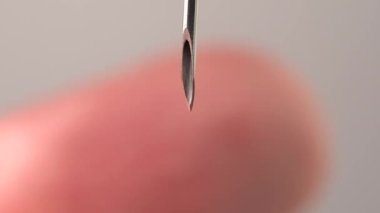 Parmak şırıngaya değiyor. Makro, kapat. Trypanofobi, enjeksiyon ya da enjeksiyon korkusu. Keskin iğneye tehlikeli bir şekilde yakın deri. Fobiler ve travmalar.