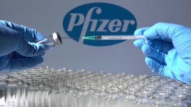Toronto, Ontario, Kanada - 14 Şubat 2021: Bir sağlık çalışanı Amerikan aşısı Pfizer 'ı uygulamaya hazırlanıyor. Aşıların adı bulanık ve mRNA teknolojisi aşısı içeren şişeler.