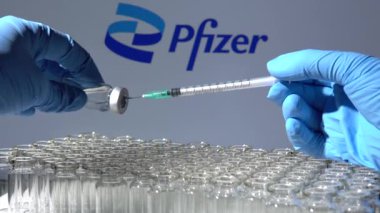 Toronto, Ontario, Kanada - 14 Şubat 2021: Pfizer aşısı. Hemşire ya da doktor, şırınga ve şişe tutarak Amerikan aşısı yapıyor. Coronavirus COVID-19 hastalığına karşı koruma.