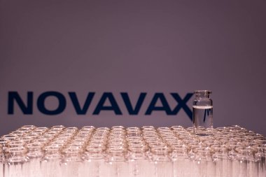 Toronto, Ontario, Kanada - 14 Şubat 2021: Novavax ismi bulanık ve aşı içeren şişeler. Amerikan Covid-19 aşı konsepti. Sığ alan derinliği.