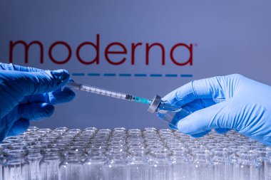 Toronto, Ontario, Kanada - 14 Şubat 2021: Bir sağlık çalışanı Amerikan aşısı Moderna 'yı uygulamaya hazırlanıyor. İsim bulanık ve içinde RNA teknolojisi aşısı bulunan şişeler.