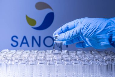 Toronto, Ontario, Kanada - 14 Şubat 2021: Sanofi o ismi bulanık. Aşı uzmanı cam şişeyi Fransız aşısıyla tutuyor. Coronavirus 'a karşı araştırma, COVID-19. Klinik değerlendirme.
