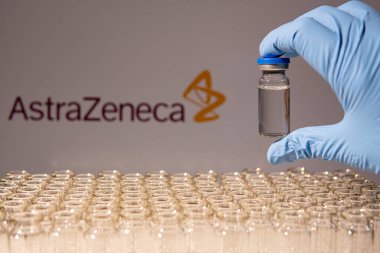 Toronto, Ontario, Kanada - 14 Şubat 2021: AstraZeneca ismi bulanık. Cam şişeyi İngiliz İsveç aşısıyla tutan bilim adamı. Coronavirus 'a karşı araştırma, COVID-19. Klinik değerlendirme.