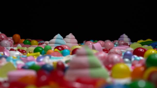 糖果和釉面包裹的糖果放在桌上 移动浅层的场 各种各样的节日糖果 棉花糖 五颜六色的糖甜点 在桌子上 — 图库视频影像