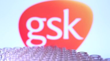Toronto, Ontario, Kanada - 14 Şubat 2021: GSK GlaxoSmithKline ismi bulanık ve aşı içeren şişeler hareket ediyor. İngiliz Covid-19 aşı konsepti. Sığ alan derinliği taşınıyor.