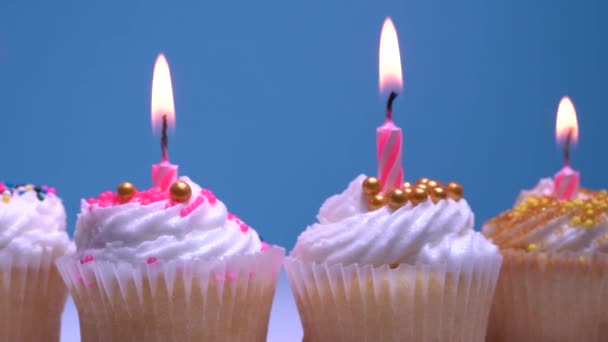 Födelsedag Cupcakes Med Brinnande Ljus Blå Bakgrund Rotation Vanilj Kokosmuffins — Stockvideo