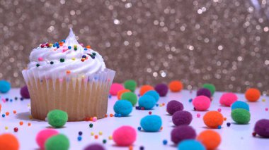 Cupcake makro sığ alan derinliği ve şeker parçacıkları ile dekorasyon. Altın kaplamalı beyaz vanilyalı kek. Lezzetli tatlılar yapma süreci. Teslimat ya da satış için kek.. 