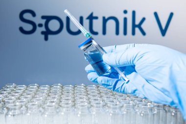 Toronto, Ontario, Kanada - 14 Şubat 2021: Bir sağlık çalışanı Rus aşısı Sputnik V 'nin bir aşısını uygulamaya hazırlanıyor. Aşı adı bulanık ve Gam-COVID-Vac içeren aşı şişeleri.