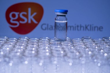Toronto, Ontario, Kanada - 14 Şubat 2021: GSK GlaxoSmithKline ismi bulanık ve aşı içeren şişeler. İngiliz Covid-19 aşı konsepti. Sığ alan derinliği.