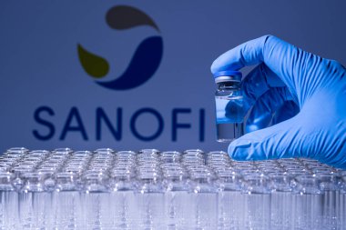 Toronto, Ontario, Kanada - 14 Şubat 2021: Sanofi o ismi bulanık. Aşı uzmanı cam şişeyi Fransız aşısıyla tutuyor. Coronavirus 'a karşı araştırma, COVID-19. Klinik değerlendirme.