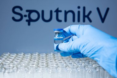 Toronto, Ontario, Kanada - 14 Şubat 2021 Sputnik V adı bulanık. Cam şişeyi Rus aşısıyla tutan bilim adamı. Coronavirus 'a karşı araştırma, COVID-19. Klinik değerlendirme.