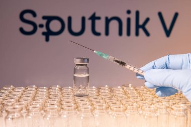Toronto, Ontario, Kanada - 14 Şubat 2021: Bir sağlık çalışanı Rus aşısı Sputnik V 'nin bir aşısını uygulamaya hazırlanıyor. Aşı adı bulanık ve Gam-COVID-Vac içeren aşı şişeleri.