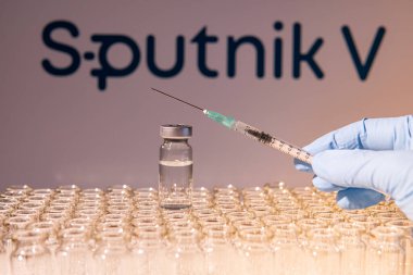 Toronto, Ontario, Kanada - 14 Şubat 2021: Bir sağlık çalışanı Rus aşısı Sputnik V 'nin bir aşısını uygulamaya hazırlanıyor. Aşı adı bulanık ve Gam-COVID-Vac içeren aşı şişeleri.