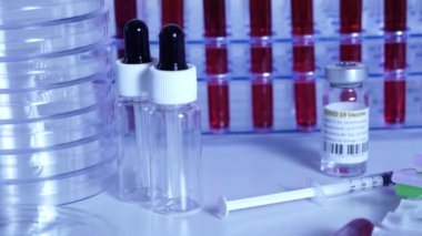 COVID-19 aşısı ve şırınga hareket ediyor. Coronavirus aşısı olan ampuller ve şişeler doktor masasında hazır. Tıp uzmanları tarafından yapılan kas içi aşılama..