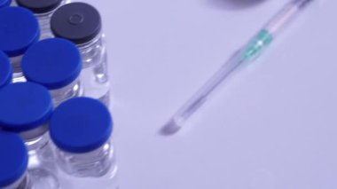 COVID-19 aşı ve şırınga. Doktor ya da hemşire masasında hazırlanmış koronavirüs aşısı olan tüpler ve ampuller. Tıp uzmanları tarafından yapılan kas içi aşılama..