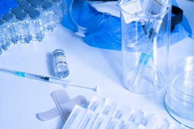 Aşı tüpleri ve şırıngalarda COVID 19 tedavisi var. Atışı yapmaya hazırız. Coronavirus 'a karşı tıbbi araştırma. İlaçlar, ilaçlar ve Pip sağlık çalışanlarının masasında..