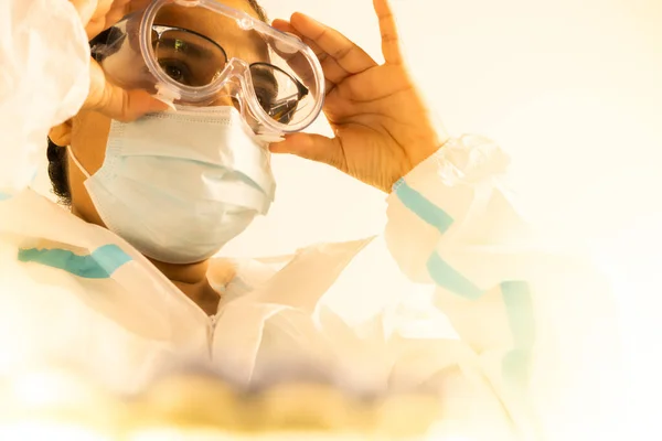 コロナウイルスパンデミック時の女性医師または看護師Covid 最前線の医療従事者は 抗ウイルススーツや衣装に置かれたパイプ 眼鏡やマスクで ワクチン研究室の医療従事者 — ストック写真