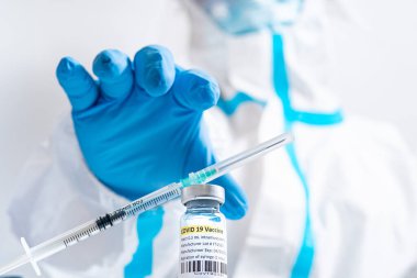 Aşı şişesi ve COVID 19 tedavisi içeren şırınga. Atışı yapmaya hazırız. Coronavirus 'a karşı tıbbi araştırma. Tıp işçilerinin masasında bulunan solunum sendromu virüsünün aşısı..