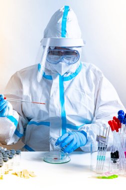 Kadın bilim adamı tıbbi virüs laboratuvarında çalışıyor ve bir koronavirüs aşısı geliştiriyor. COVID-19 hastane araştırması. Doktor Petri kabı pipeti, çeşitli doku ve kan örnekleri üzerinde çalışıyor.. 