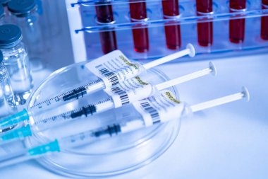 COVID-19 aşı ve şırınga. Doktor ya da hemşire masasında hazırlanmış koronavirüs aşısı olan tüpler ve ampuller. Tıp uzmanları tarafından yapılan kas içi aşılama..