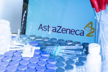 Toronto, Ontario, Kanada - 20 Nisan 2021: Bulanık AstraZeneca adı, hemşire masasında aşı bulunan şişeler ve şırıngalar. İngiliz Koronavirüs aşısı konsepti. Sığ alan derinliği.