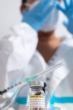 Aşı şişesi ve COVID 19 tedavisi içeren şırınga. Atışı yapmaya hazırız. Coronavirus 'a karşı tıbbi araştırma. Tıp işçilerinin masasında bulunan solunum sendromu virüsünün aşısı..