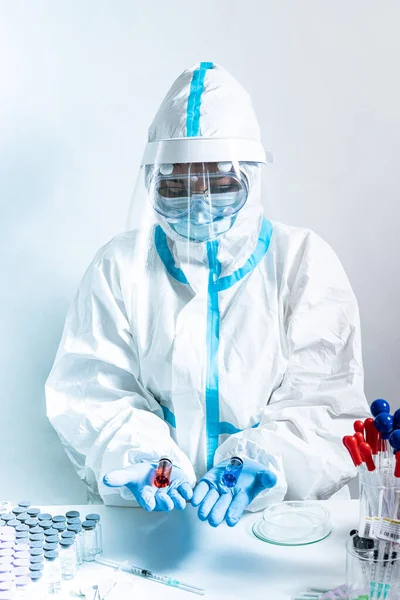 安全手袋と保護マスクの医療看護師は ガラスのバイアルに異なるワクチン注射を示しています 銅の医療従事者は Covid 19免疫のための様々なワクチンの選択肢を与えます — ストック写真
