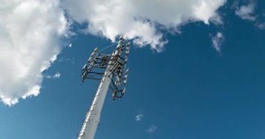Cep telefonu iletişim antenleri, 3G, 4G, 5G, 6G. Yazın bulutlu mavi gökyüzünü hızla hareket ettiren antenin zaman akışı. Vericili hücresel GSM kulesi. Telekomünikasyon baz istasyonu ağı.