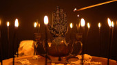 Řečnická ruka nebo palmistry na čarodějnickém stole se zvířecími kostmi. Palmistry s černou dlaní a svíčkami ve svícnu. Symbol magické alchymie. Čtení dlaní v mystické okultní místnosti.
