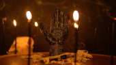 Tajemný esoterický stůl s rituálními předměty. Palma věštkyně s černými svíčkami a zvířecími kostmi na povrchu kmene stromu. Předpověď osudu a předpovědi budoucí ruční čtečka socha. 