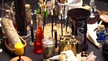 Esrarengiz ve esrarengiz büyücü doktor hala hayatta. Sihirli objelerle Cadılar Bayramı. Siyah mumlar, keçi kafatası, dişler ve adaçayı, tavuk parmağı ve kum saati olan iksir şişeleri. Yabani otlu mistik cadılık.